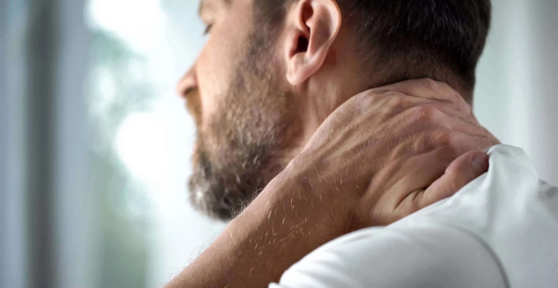 Man grijpt naar nek vanwege whiplash klachten | Bodycare Fysiotherapie en Leefstijl in Son en Breugel